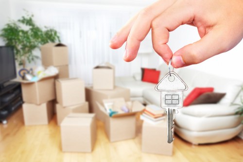 Professional removals staff carrying a sofa through a property