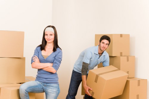 Professional movers handling furniture in an Ilford residential street